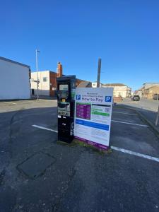 a pay box sitting in a parking lot at AQUARIUS APARTMENT - SEA VIEW - SLEEPS SEVEN in Blackpool
