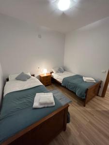 a bedroom with two beds and a night stand with a lamp at Frente al puerto y junto a la playa del Arenal in Burriana