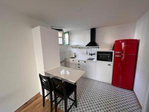 een keuken met een rode koelkast en een tafel en stoelen bij Estudio Bolingas in Comillas