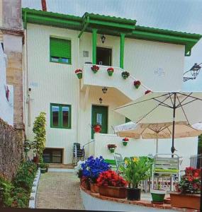 een huis met een paraplu en bloemen ervoor bij Estudio Bolingas in Comillas