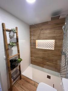 a bathroom with a toilet and a wooden wall at Estudio Bolingas in Comillas