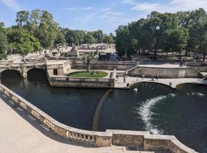 a bridge over a river in a park at Maison entière avec terrasse barbecue et jardin in Nîmes