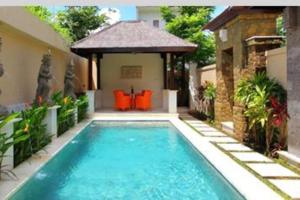 Private villa with private pool near GWK في جيمباران: مسبح في الحديقة الخلفية للمنزل
