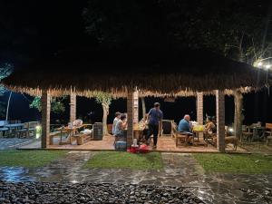 Un gruppo di persone sedute intorno a un padiglione di notte di Pu Luong - Duy Phuong Homestay a Thanh Hóa