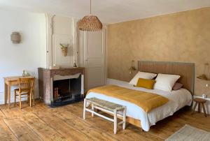 a bedroom with a bed and a fireplace at Maison d'hôtes et gîte de charme avec piscine, La Lhuiseraie in Lhuis