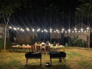 a group of people sitting at tables under lights at Pu Luong - Duy Phuong Homestay in Thanh Hóa