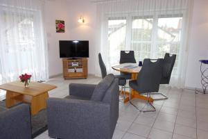 a living room with a table and chairs and a tv at Ferienwohnungen Böhme in Konstanz