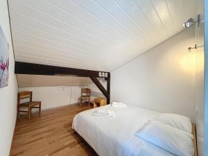 a bedroom with a white bed in a attic at Marie-Rose 8 in Bagnes