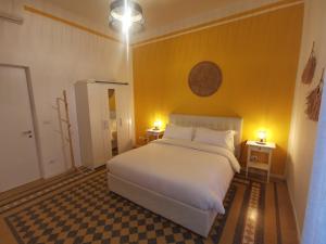 sypialnia z białym łóżkiem i 2 szafkami nocnymi w obiekcie GIALLA Ridi Che Ti Passa w Alassio