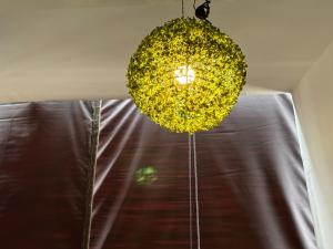 a yellow chandelier hanging from a ceiling with a window at Rukmani Villas Group of Rukmani home stay in Mathura