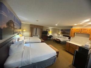 a hotel room with two beds and a living room at Days Inn by Wyndham Sturgis in Sturgis