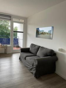 - un salon avec un canapé en face d'une fenêtre dans l'établissement Haus am Park Sünnig Utsicht, à Norderney