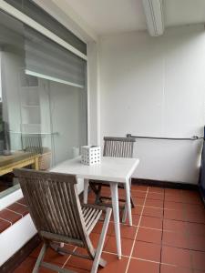 une table blanche et deux chaises dans une pièce dans l'établissement Haus am Park Sünnig Utsicht, à Norderney 2 autres photos