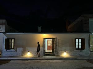 un hombre de pie fuera de un edificio por la noche en Casa Regino en Villa Cura Brochero