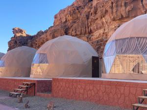 two domes with benches in front of a mountain at Lucas Camp Wadi Rum in Disah