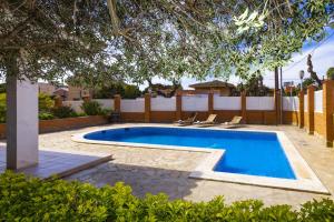 a swimming pool in a yard with chairs around it at VILADOMAT BEACH Planetcostadorada in Salou
