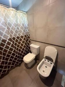 a bathroom with a toilet and a shower curtain at Casa sobre la Colina in Mar del Plata
