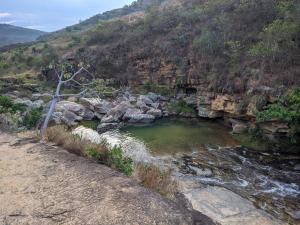 uma piscina de água num rio junto a uma montanha em Cabaña el Gaque em Curití