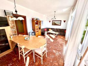 a living room with a wooden table and chairs at Villa Edith - stupenda villa con terrazzo vista mare, giardino e spiaggia inclusa in Numana