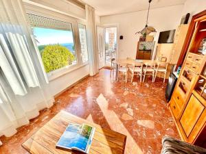 a living room with a table and a large window at Villa Edith - stupenda villa con terrazzo vista mare, giardino e spiaggia inclusa in Numana