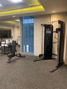 una habitación con un gimnasio con dos máquinas de correr y un escritorio en Maldron Hotel Belfast City en Belfast