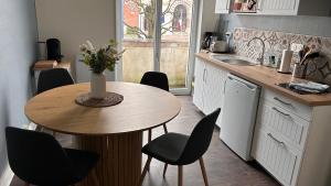 eine Küche mit einem Tisch und Stühlen sowie einem Tisch und einer Theke in der Unterkunft L'appartement de Julie in Albert