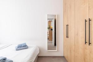 1 dormitorio con cama y espejo en SKG Cityscape Metropolis en Tesalónica