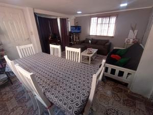 een woonkamer met een tafel en stoelen en een bank bij Hostal La Palmera in Ezeiza