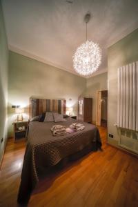 a bedroom with a large bed and a chandelier at de' Montetini in Arezzo