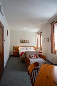 1 dormitorio con 2 camas y mesa. en Residence Cima Jazzi, en Macugnaga