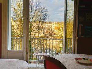 a bedroom with a view of a city from a window at La Chambre aux Hérons in Nantes