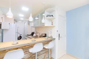 een keuken met witte stoelen en een aanrecht bij Luxo em Ipanema 304 in Rio de Janeiro