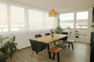 comedor con mesa, sillas y ventanas en Beautiful Apartment 10 min from Zurich! Netflix!, en Schlieren