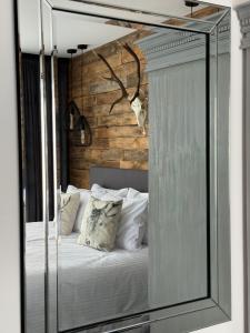 um espelho que reflecte uma cama num quarto em Framptons Murzasichle Luxury Apartments tylko dla dorosłych em Murzasichle