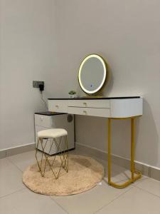 a dressing table with a mirror and a stool at Saujana Homestay Kluang in Kluang