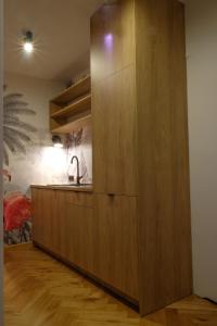 una cocina con un gran armario de madera con fregadero en Sweet Dreams Apartments Bielsko-Biała, en Bielsko-Biala 22 fotos más