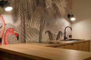 a kitchen with a tropical wallpaper on the wall at Sweet Dreams Apartments Bielsko-Biała in Bielsko-Biała