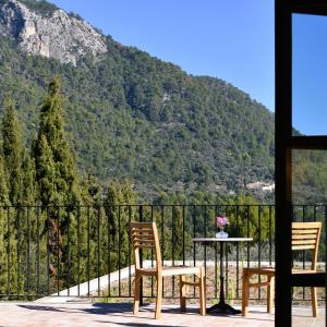 Duas cadeiras e uma mesa numa varanda com uma montanha em Finca Can Beneit em Binibona