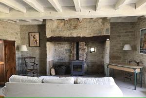 sala de estar con sofás blancos y chimenea en Le Bournissard à Cuzance, en Cuzance