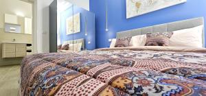 um quarto com uma cama grande e uma parede azul em Garibaldi Superior Apartment - Enjoy Your Life! em Faenza