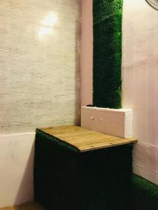 pared verde con banco de madera en una habitación en OCEAN PEARL RESIDENCY, en Kochi