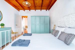 a bedroom with a white bed and a blue cabinet at Casa Tagaide in Playa Blanca