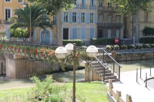 a street light next to a bridge with flowers at Le Loft De La Robine 110m2 in Narbonne