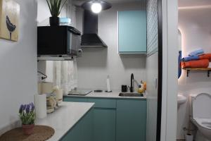 a small kitchen with blue cabinets and a sink at El Rincón de la Azucena in Guadalajara