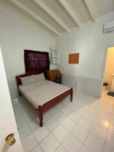 1 dormitorio con 1 cama en una habitación blanca en Thrillers Apartments en Gwa Kay