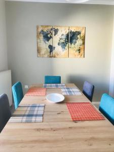 a table with blue chairs and a white plate on top at Central Family Apartment in Preveza