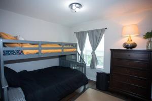 a bedroom with bunk beds and a dresser with a lamp at New Townhome Near Downtown-King Bed/Workstation in Naperville