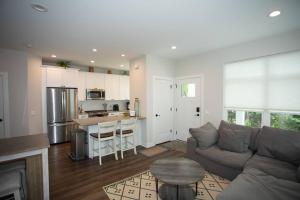 a living room with a couch and a kitchen at New Townhome Near Downtown-King Bed/Workstation in Naperville