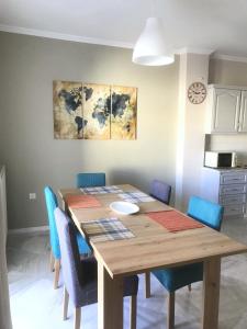 a dining room table with blue chairs around it at Central Family Apartment in Preveza