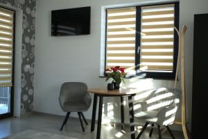 Un comedor con una mesa y dos sillas. en Vila Dorna Royal, en Şarul Dornei